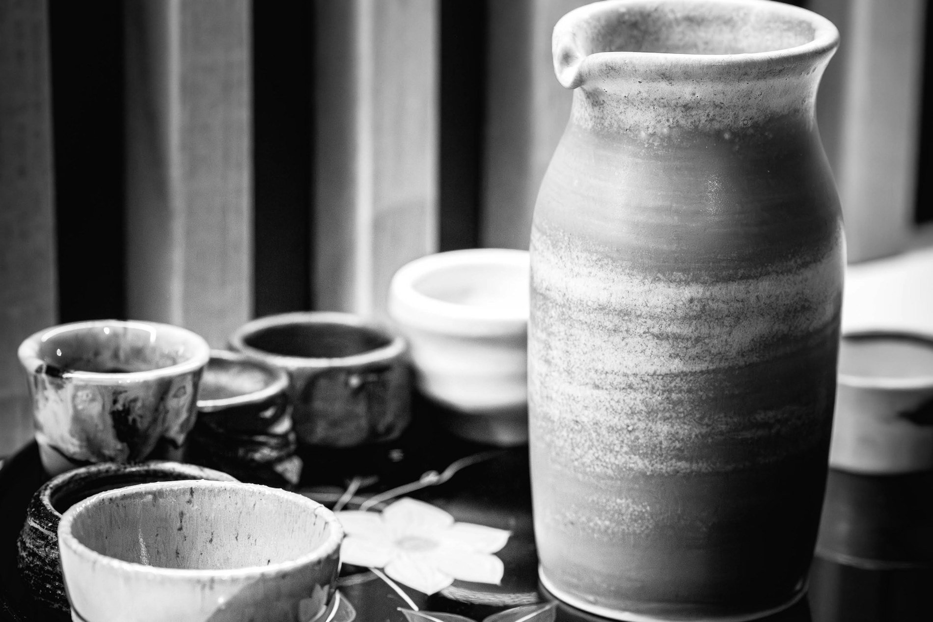 A sake flask and small cups on a lacquer tray