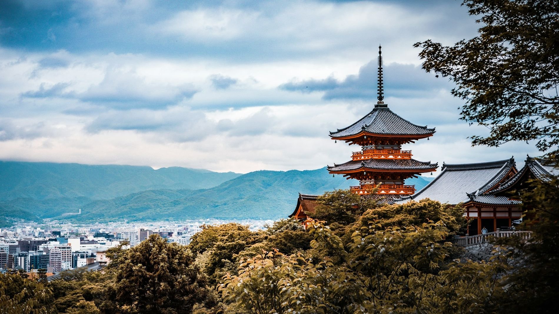 The red pagoda of a Kyoto temple rising above the city rooftops