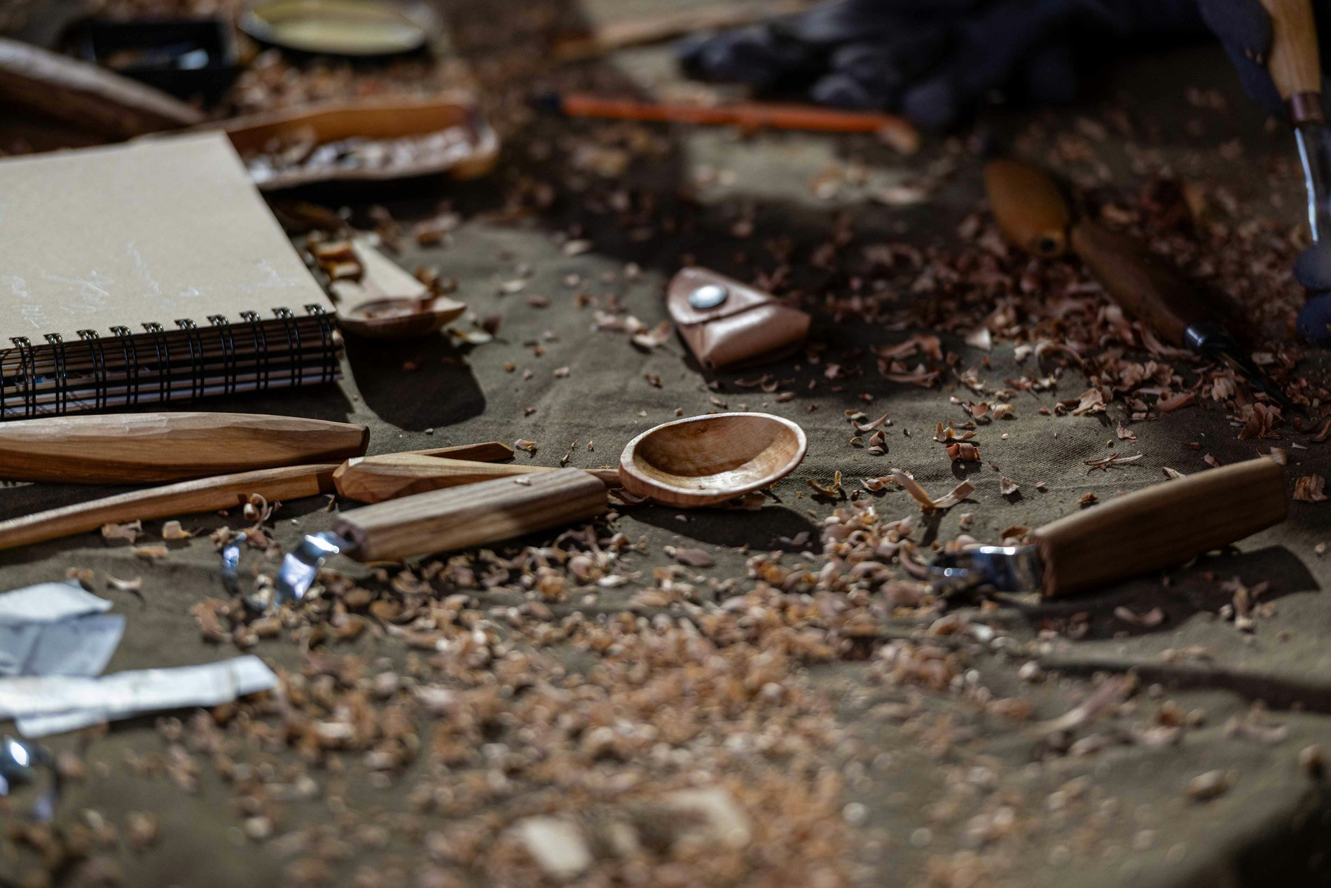 Wood-carving tools and shavings on a workbench