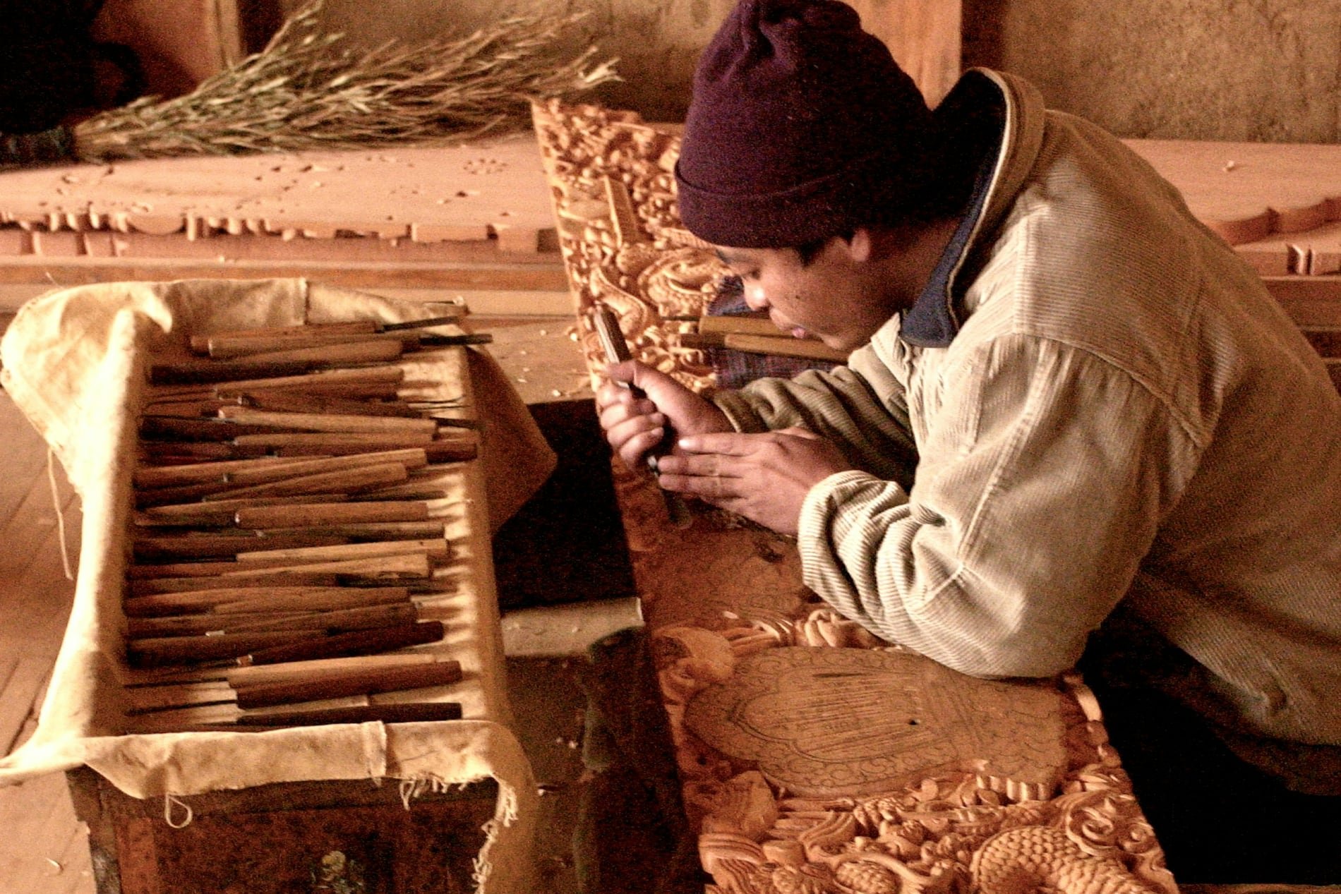 A craftsman carving a dragon relief in wood