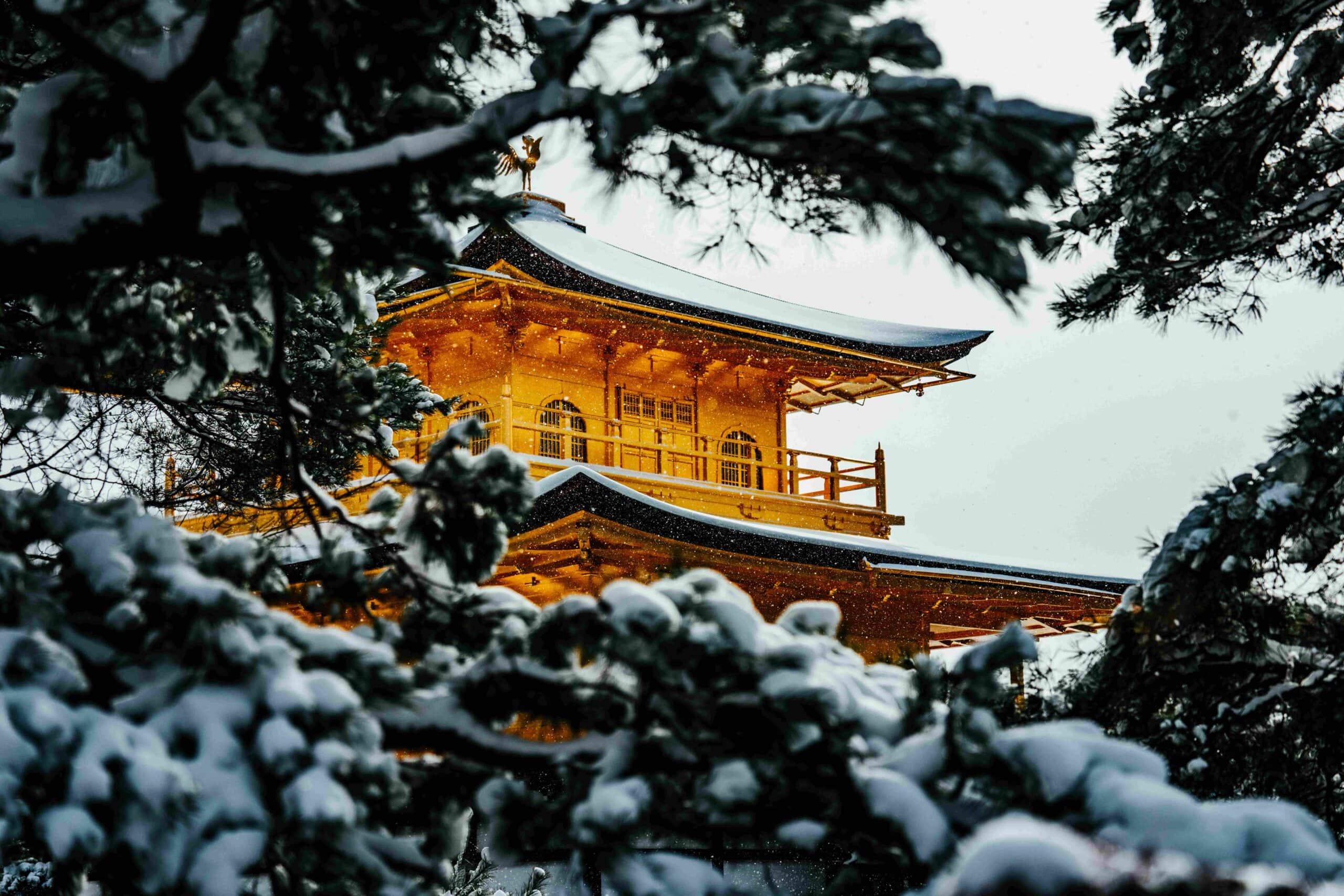 Kinkaku-ji Golden Pavilion dusted with snow in winter reflected in a still pond, Kyoto Japan