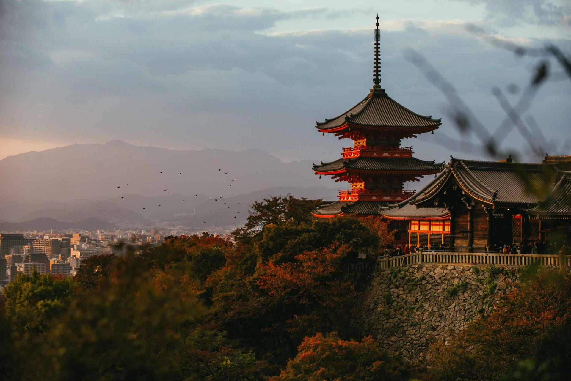 A pagoda above the rooftops of Kyoto at dusk, Japan
