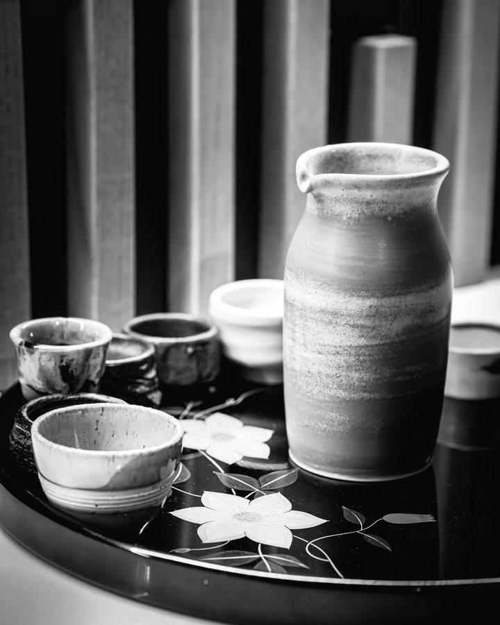 A sake flask and small cups on a lacquer tray